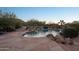 Beautiful pool with rock features and lush landscaping in a serene backyard setting at 11255 S San Adrian Ln, Goodyear, AZ 85338