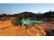 Inviting pool with rock accents and steps, surrounded by desert landscaping at 11255 S San Adrian Ln, Goodyear, AZ 85338