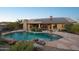 Large backyard pool with stone accents, solar panels, desert landscaping, and a calming desert vibe at 11255 S San Adrian Ln, Goodyear, AZ 85338
