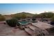 Lush backyard pool area with rock features, mature desert landscaping, and a serene ambiance at 11255 S San Adrian Ln, Goodyear, AZ 85338