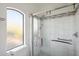 Modern shower with marble tile, grab bars, and natural light at 11255 S San Adrian Ln, Goodyear, AZ 85338