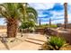 Backyard featuring a built-in outdoor kitchen and bar, a tiled patio, desert landscaping and palm trees at 1173 E Daisy Way, San Tan Valley, AZ 85143