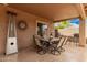 Cozy covered patio with an outdoor dining table, chairs, and heater for comfortable outdoor living at 1173 E Daisy Way, San Tan Valley, AZ 85143
