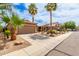 Wide view of a stucco house with a driveway, a two-car garage, desert landscaping, and palm trees at 1173 E Daisy Way, San Tan Valley, AZ 85143