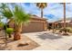 Attached garage with a driveway and desert landscaping including palm trees and cacti at 1173 E Daisy Way, San Tan Valley, AZ 85143