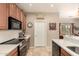 Efficient kitchen layout with updated appliances, tile flooring, and access to the dining room at 1173 E Daisy Way, San Tan Valley, AZ 85143