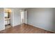 Bedroom features wood floors, neutral colored walls, and an entrance into an attached bathroom at 12233 W Aster Dr, El Mirage, AZ 85335