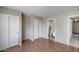 Bedroom featuring wood floors, dual closets, neutral wall colors, and an attached bath at 12233 W Aster Dr, El Mirage, AZ 85335