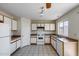 Bright kitchen with a window overlooking the backyard, tile floors, and plenty of white cabinets at 12233 W Aster Dr, El Mirage, AZ 85335