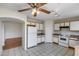 Open kitchen with white cabinets, a ceiling fan, and a view into an adjacent room at 12233 W Aster Dr, El Mirage, AZ 85335