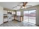 Bright kitchen featuring white appliances, cabinets, and a sliding glass door leading to the backyard at 12233 W Aster Dr, El Mirage, AZ 85335