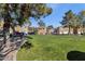 Green community space with lush lawn, mature trees, and picnic tables for residents to enjoy at 1335 E June St # 107, Mesa, AZ 85203