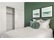 Bedroom featuring a closet with sliding doors and green accent wall with two scenic prints at 1342 W Hess Ave, Coolidge, AZ 85128