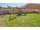 A well-maintained backyard with a lush green lawn and a playset providing outdoor fun at 1556 E Gabrilla Dr, Casa Grande, AZ 85122