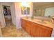 Bathroom featuring double sinks with wooden cabinetry and a closet in the background, adding practical storage at 1556 E Gabrilla Dr, Casa Grande, AZ 85122
