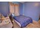 Comfortable bedroom with a blue bedspread, desk, and natural light, perfect for study and rest at 1556 E Gabrilla Dr, Casa Grande, AZ 85122