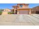 Two-story home featuring a spacious driveway and low-maintenance landscaping under a clear blue sky at 1556 E Gabrilla Dr, Casa Grande, AZ 85122