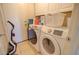 Efficient laundry room with white washer and dryer, cabinets, and convenient tile flooring at 1556 E Gabrilla Dr, Casa Grande, AZ 85122