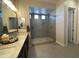 The bathroom features a spacious glass shower enclosure with pebble flooring, and a double sink vanity at 15801 W Cielo Grande Ave, Surprise, AZ 85387