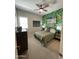 A cozy bedroom with a fan, neutral walls, leaf print wallpaper, and natural light at 15801 W Cielo Grande Ave, Surprise, AZ 85387