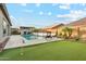 Lush backyard featuring a sparkling pool, putting green, and stylish outdoor seating at 16852 W Creedance Blvd, Surprise, AZ 85387