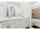 Bathroom featuring double sinks with a white vanity, a large mirror, and a combined shower and bathtub at 16852 W Creedance Blvd, Surprise, AZ 85387