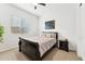 Cozy bedroom featuring a black bed frame, nightstand, ceiling fan, and window with blinds at 16852 W Creedance Blvd, Surprise, AZ 85387