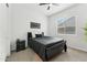 Well-lit bedroom featuring a black bed, nightstand, ceiling fan, and window with blinds at 16852 W Creedance Blvd, Surprise, AZ 85387