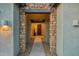 Covered entryway featuring a stone facade, a pathway, and a view of the front door at 16852 W Creedance Blvd, Surprise, AZ 85387