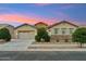 Charming single-story home featuring a stone facade, desert landscaping, and a two-car garage in a serene neighborhood at 16852 W Creedance Blvd, Surprise, AZ 85387