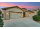 Spacious three-car garage with a wide driveway, offering ample parking and storage space for vehicles and equipment at 16852 W Creedance Blvd, Surprise, AZ 85387