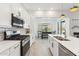 Contemporary kitchen featuring stainless steel appliances, white cabinets, and ample natural light at 16852 W Creedance Blvd, Surprise, AZ 85387