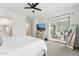 Bright main bedroom featuring a ceiling fan, dresser with TV, and glass sliding door to the outside at 16852 W Creedance Blvd, Surprise, AZ 85387