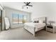 Bright main bedroom showing a large bed, window with blinds, and a mirror against the wall at 16852 W Creedance Blvd, Surprise, AZ 85387