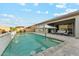 Sparkling swimming pool with a waterfall feature, an umbrella, and a cozy lounge area at 16852 W Creedance Blvd, Surprise, AZ 85387