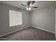 Bedroom features neutral carpet, ceiling fan, and a window providing natural light at 1804 W Kristal Way, Phoenix, AZ 85027