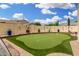 The backyard features a putting green surrounded by colorful potted plants and unique wall decor at 1912 S Colt Dr, Gilbert, AZ 85295