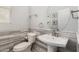 Stylish half bathroom featuring pedestal sink, decorative mirror, and marble tile accent wall at 1912 S Colt Dr, Gilbert, AZ 85295