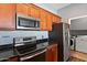 A kitchen featuring stainless steel appliances, granite countertops, and wooden cabinets at 19475 N Grayhawk Dr # 2151, Scottsdale, AZ 85255