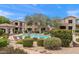 Community pool area with lounge chairs, lush landscaping, and a view of the surrounding residential buildings at 19475 N Grayhawk Dr # 2151, Scottsdale, AZ 85255