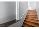 Elegant wooden staircase featuring a sleek white handrail against gray walls, leading to the upper level at 19475 N Grayhawk Dr # 2151, Scottsdale, AZ 85255