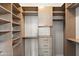 Well-organized walk-in closet featuring custom shelving and drawers at 19475 N Grayhawk Dr # 2151, Scottsdale, AZ 85255