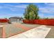 Backyard featuring a detached garage and gravel and brick trim, surrounded by a wooden fence and lush trees at 2122 W Virginia Ave, Phoenix, AZ 85009
