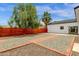 Wide backyard featuring fresh gravel and brick trim, framed by a wood fence and well-manicured trees at 2122 W Virginia Ave, Phoenix, AZ 85009