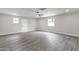 Large room enhanced with gray wood-look floors, a ceiling fan, and ample natural light from multiple windows at 2122 W Virginia Ave, Phoenix, AZ 85009