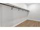 Walk-in closet featuring a minimalist design with a sturdy black metal closet rod and durable wood laminate floors at 2122 W Virginia Ave, Phoenix, AZ 85009