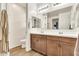 Bathroom with dual vanity sinks, neutral tile flooring, and a large mirror at 21667 S 225Th Way, Queen Creek, AZ 85142
