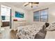 Bright bedroom features a ceiling fan, TV, wood-look floors, and an en suite bathroom at 21667 S 225Th Way, Queen Creek, AZ 85142