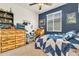 Cozy bedroom with blue accent wall, quirky decor, and a rustic wooden dresser at 21667 S 225Th Way, Queen Creek, AZ 85142