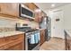 Well-equipped kitchen with stainless steel appliances, granite countertops, and brown wood cabinetry at 21667 S 225Th Way, Queen Creek, AZ 85142